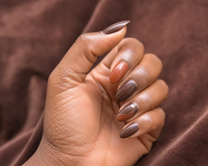 Warm brown and rust almond November nails with a fine gold curve