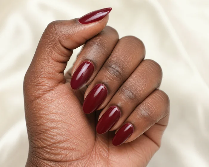 Glossy burgundy simple fall nails in a hand-only close-up