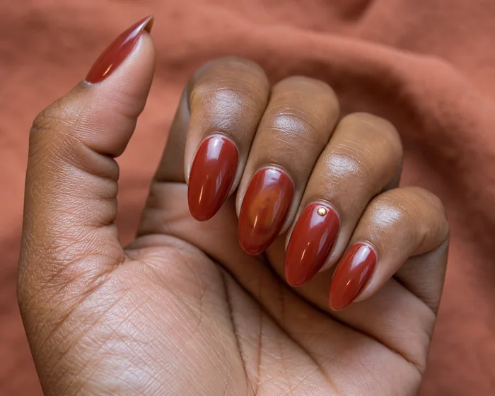 Brick red Thanksgiving dip nails with amber halo and gold dot