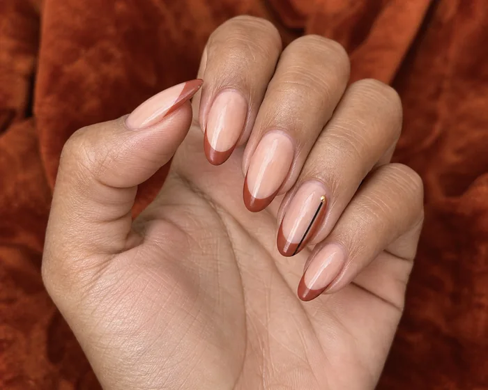 Muted rust French nails with cocoa side stripe