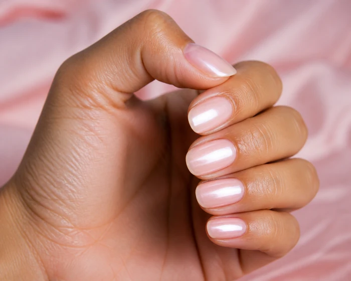Blush pearl shimmer soft fall nails in a hand-only close-up