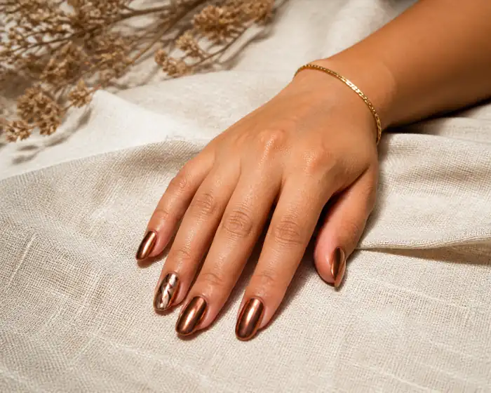 Bronze chrome fall almond nails on warm linen
