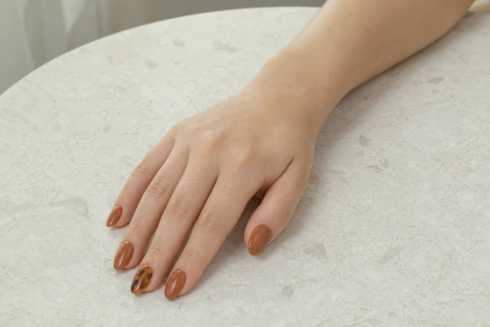 Caramel almond gel nails with a tortoiseshell accent