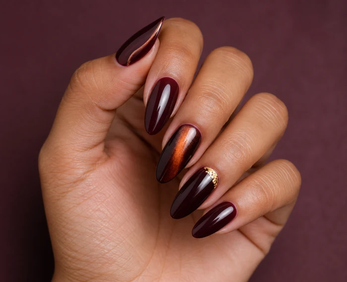 Long merlot almond nails with amber cat-eye glow