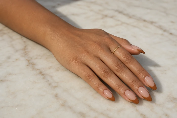 Caramel French tip dip powder nails on a marble table