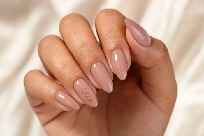 Warm nude nails with a tiny leaf accent