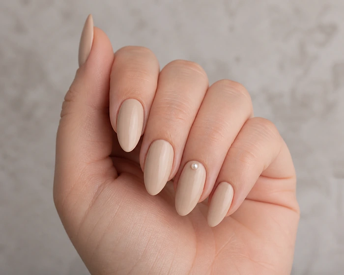 Creamy beige soft fall nails with a pearl accent