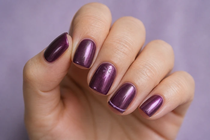 Plum chrome winter nails with a delicate snowflake detail