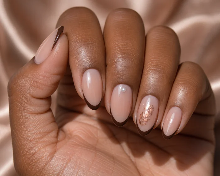 Nude short nails with a brown micro-French and tiny leaf detail