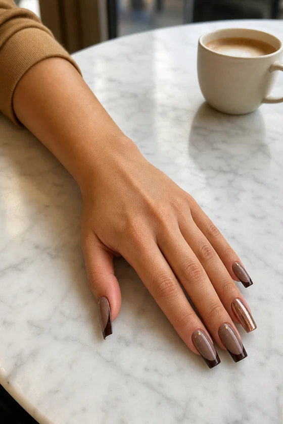 Long smoky taupe square fall nails with chocolate French tips on a cafe table