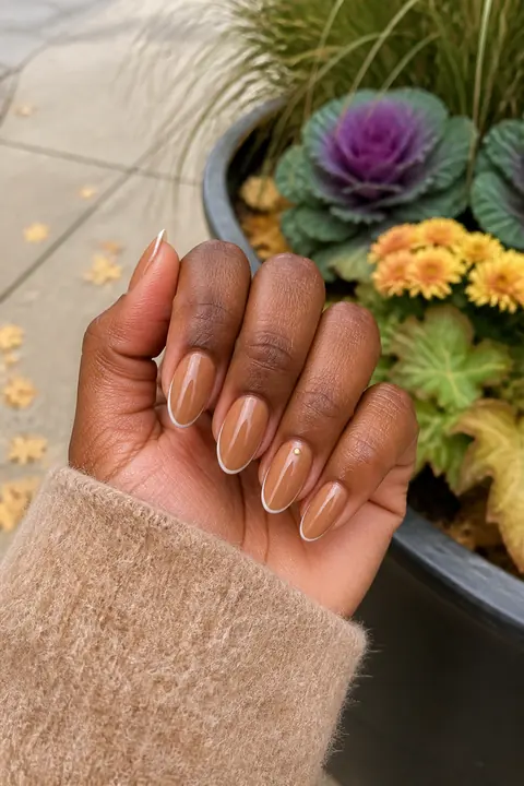Honey brown nails with cream micro French tips outdoors
