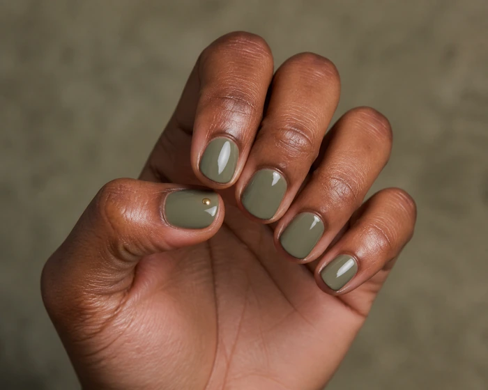 Short round olive nails with a tiny warm gold dot