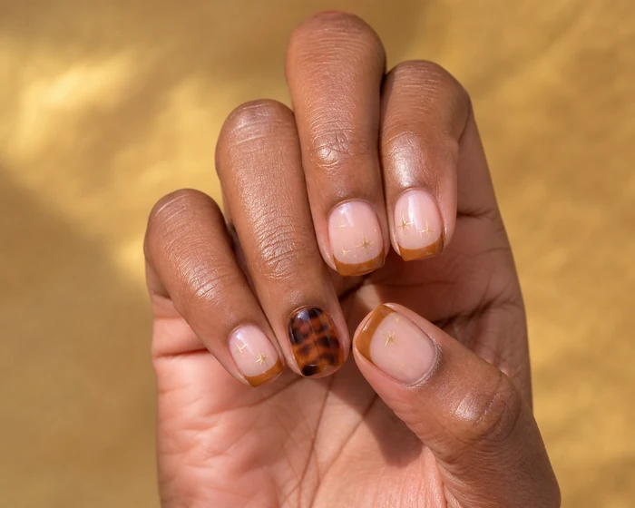 Short caramel French nails with stars and tortoiseshell accent