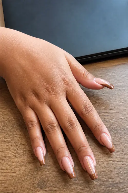 Caramel French tip coffin nails with gold line accent