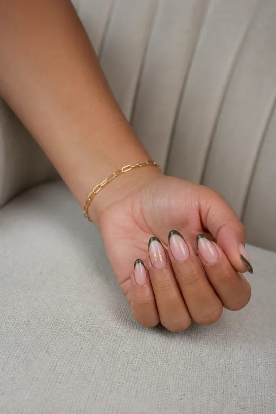 Olive glazed French tip fall almond nails on a bench