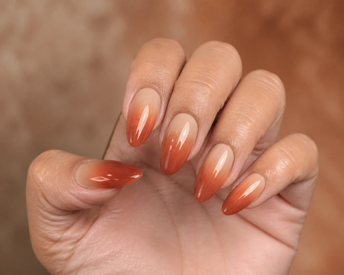 Latte to rust gel ombre almond nails with glassy shine