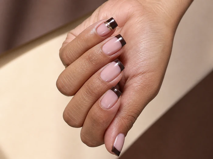 Nude square nails with crisp cocoa French tips and gold line
