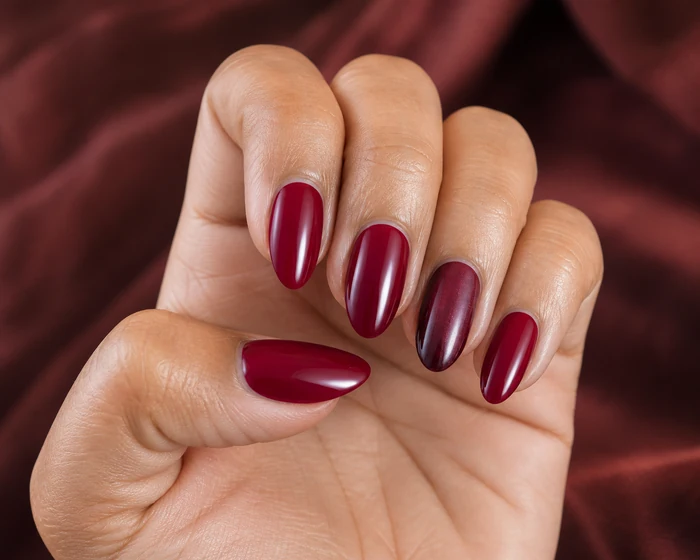 Deep cranberry Thanksgiving nails in a hand-only close-up