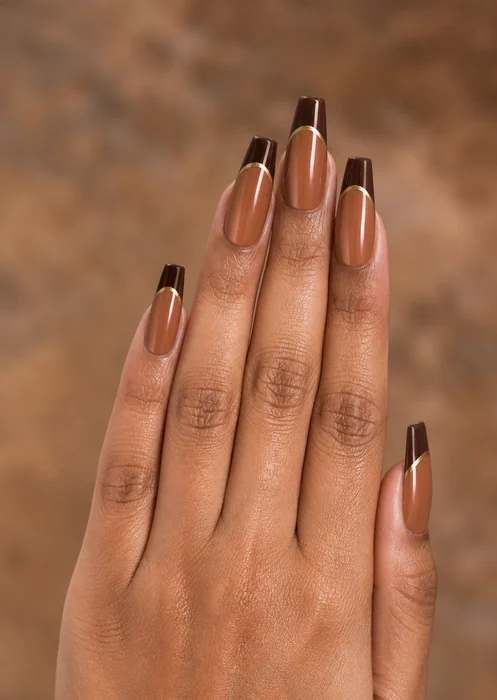 Long caramel coffin acrylic nails with gold-edged French tips