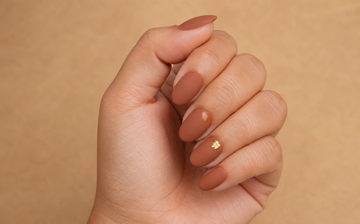 Cute matte terracotta Thanksgiving nails with gold leaf detail