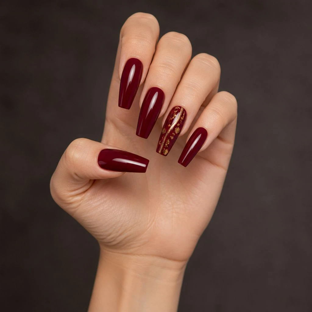 Long burgundy coffin acrylic nails with delicate gold foil