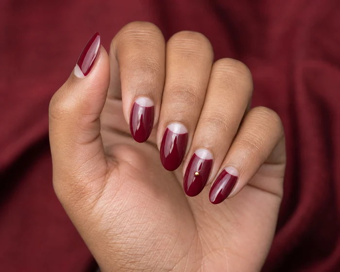 Cranberry nails with negative-space half-moons