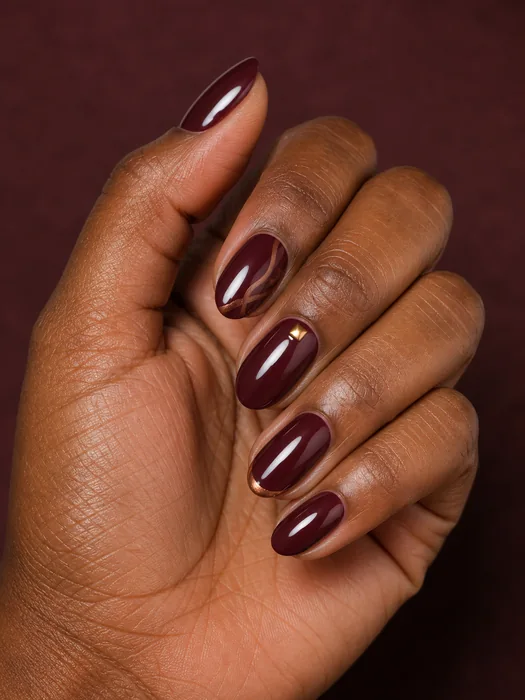 Short cranberry almond nails with copper swirl and gold foil