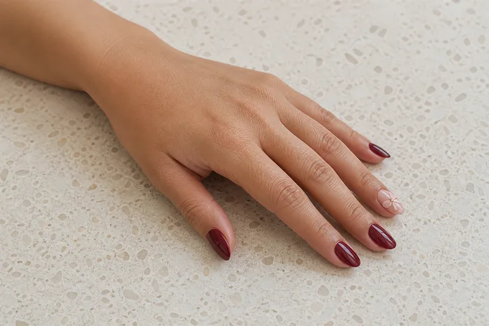 Burgundy nails with a blush bow accent