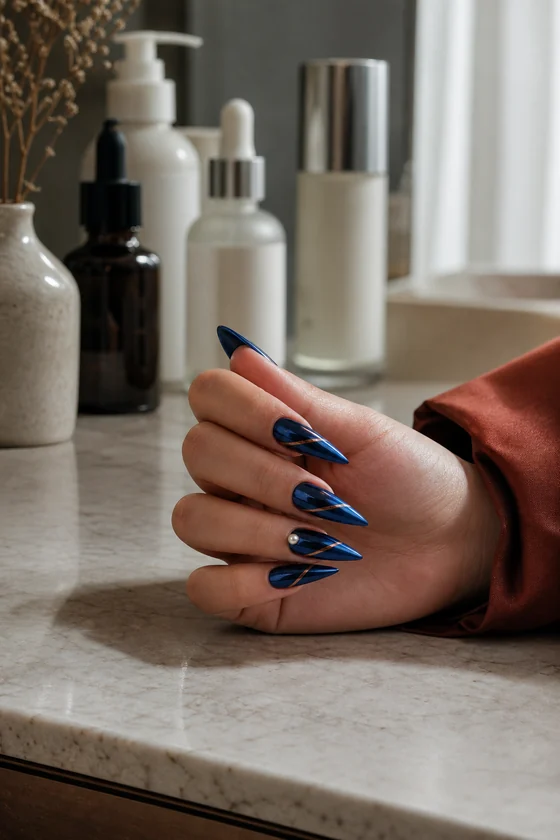 Navy mirror chrome fall stiletto nails on a bathroom vanity
