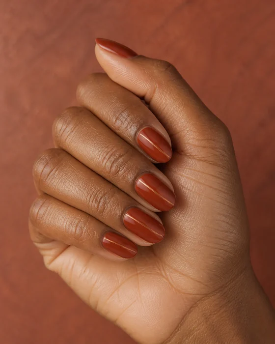 Short rust almond nails with subtle copper leaf line