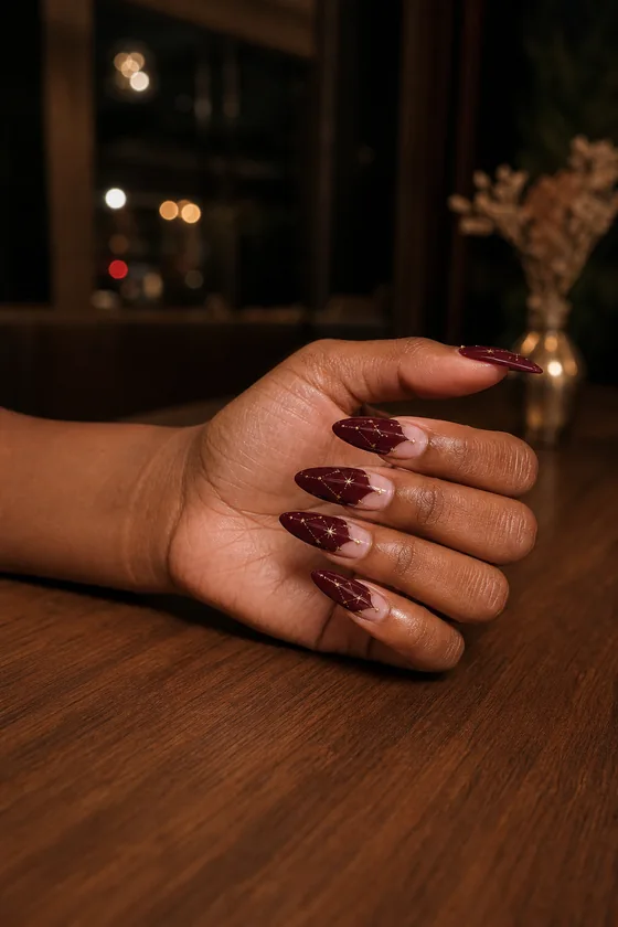 Long wine red almond fall nails with gold constellation nail art at dinner