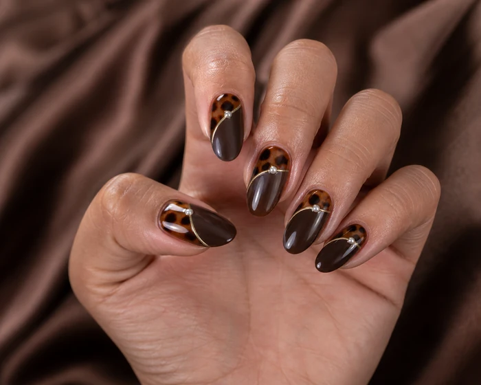 Deep brown nails with tortoiseshell crescents and pearls