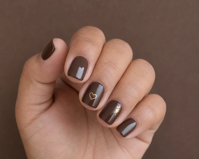 Short cocoa squoval nails with tiny gold heart and foil detail