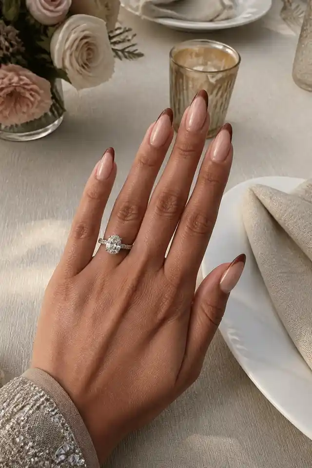 Long french tip nails at a candlelit dinner table