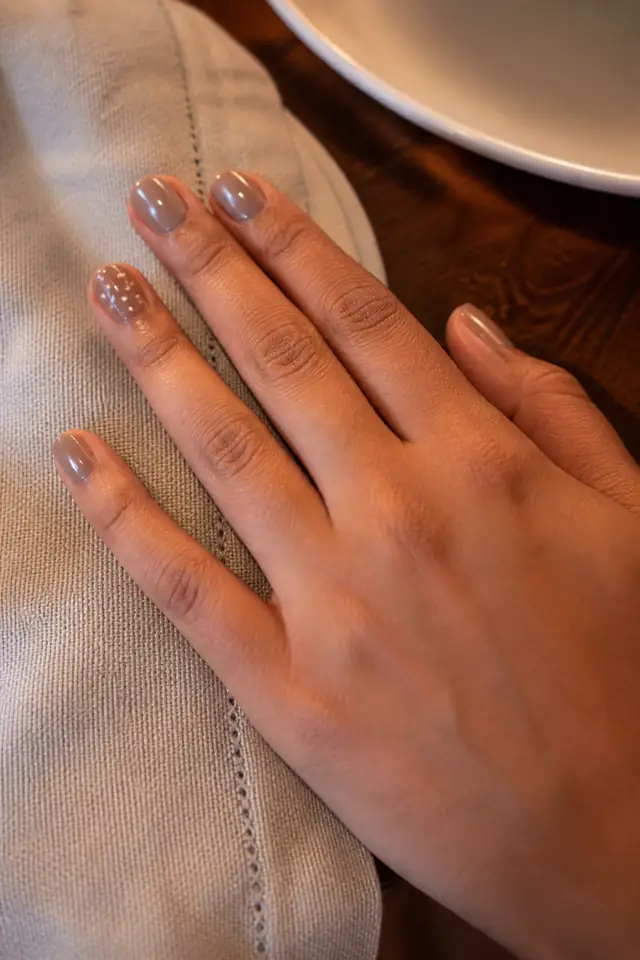 Short Polka Dot Accent short autumn nail design on a woman’s hand.
