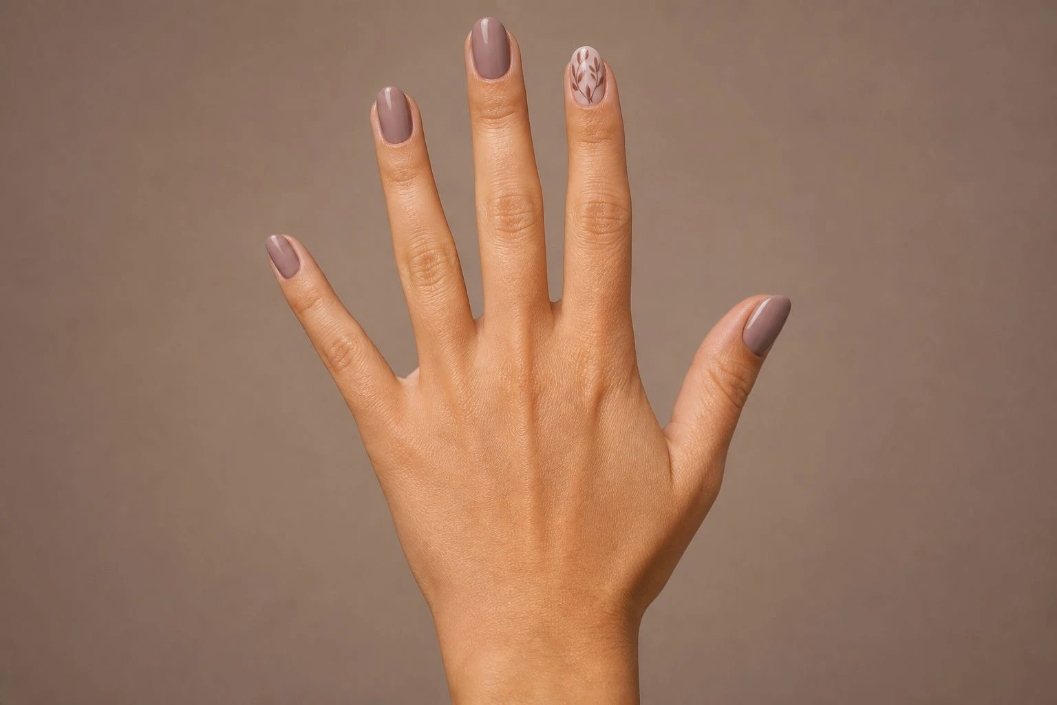 Fine-Line Autumn Leaves nails on a woman’s hand, hand-only studio macro shot.