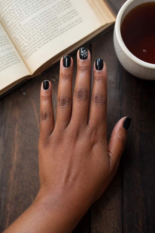 Black nails with tiny silver snowflake art