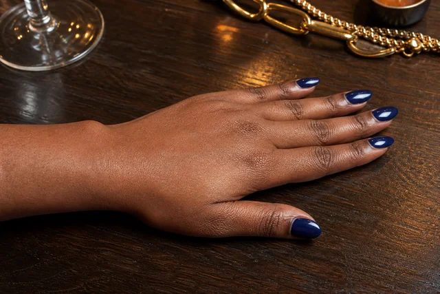 Deep navy almond Christmas nails on a woman’s full hand