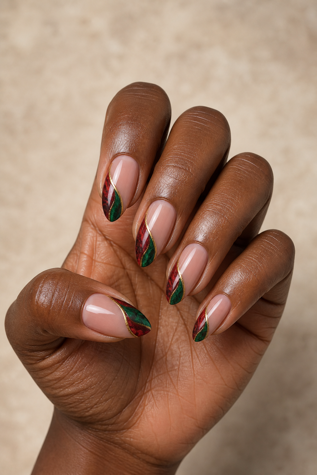 Red and green marble-ribbon Christmas nails with fine gold detail.