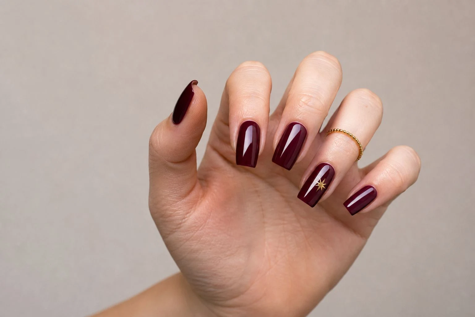 Long Burgundy Gel Set Christmas nails with a delicate gold ring
