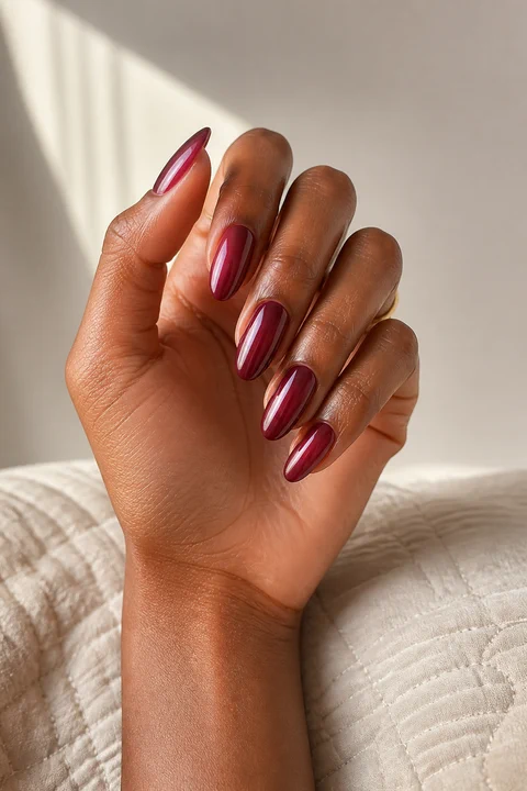 dark cherry red glazed glossy nails on a tan skin tone hand with visible wrist