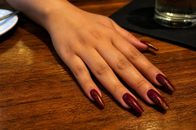 12 long coffin fall nail inspo on a woman’s full hand.