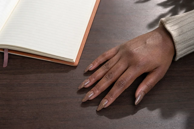14 long tapered art fall nail inspo on a woman’s full hand.