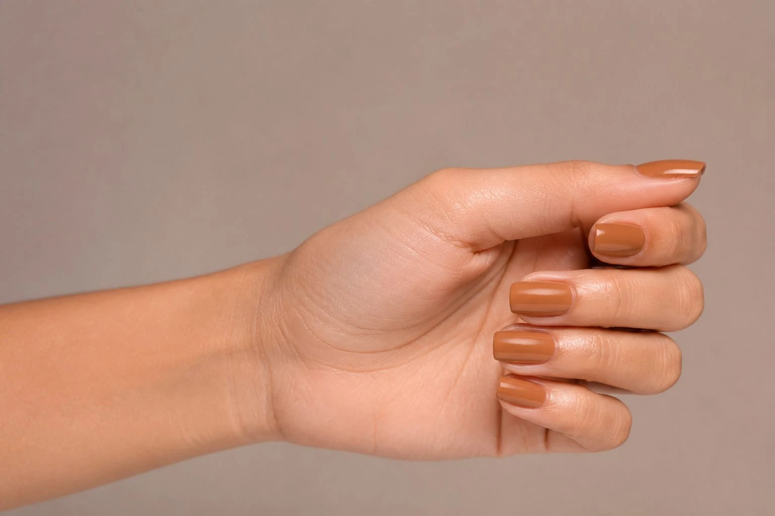 Toffee brown square nails in a relaxed curled hand pose