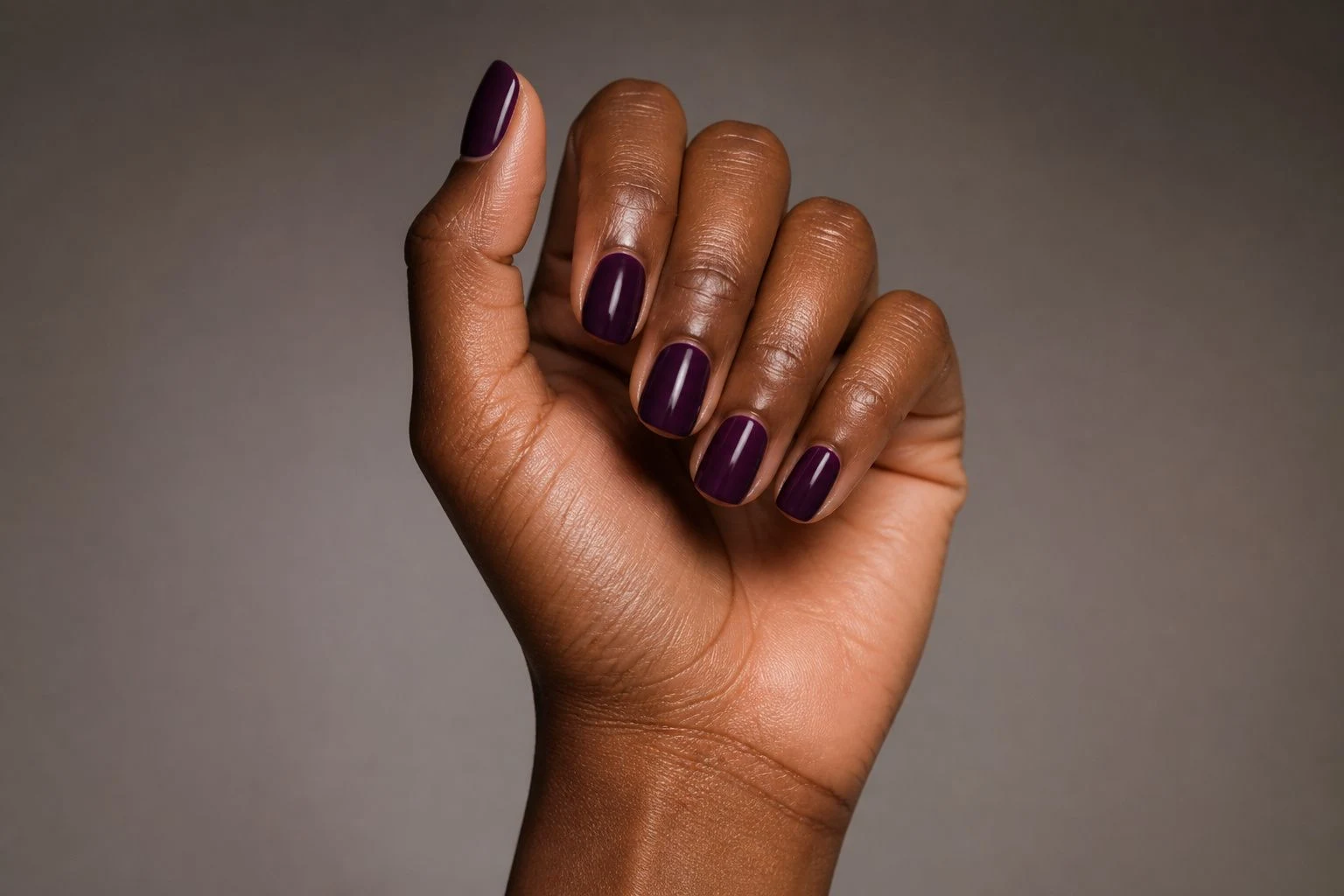 Deep violet square nails in a tilted curled hand pose