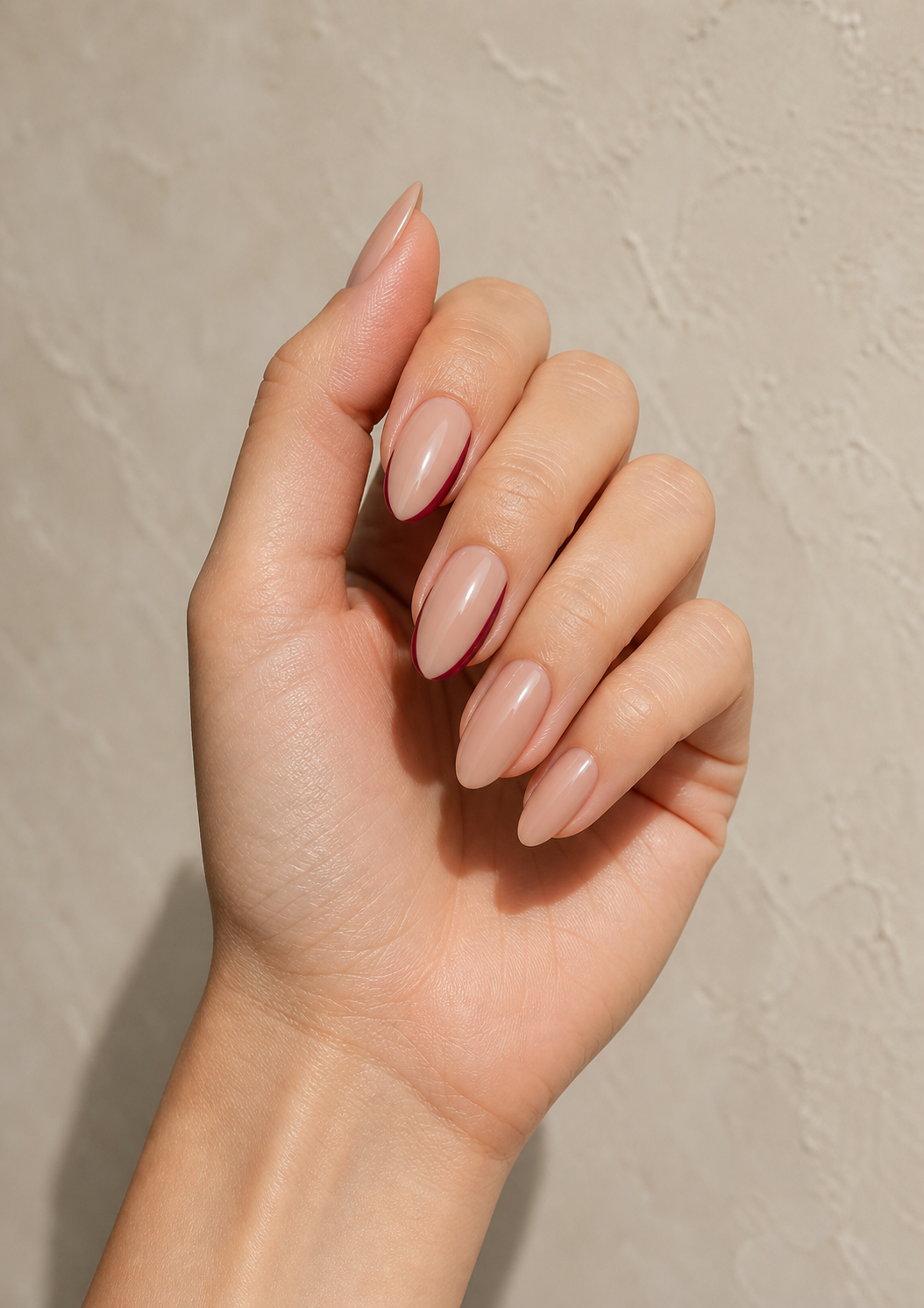 Nude fall nails on a woman’s hand with soft natural lighting.