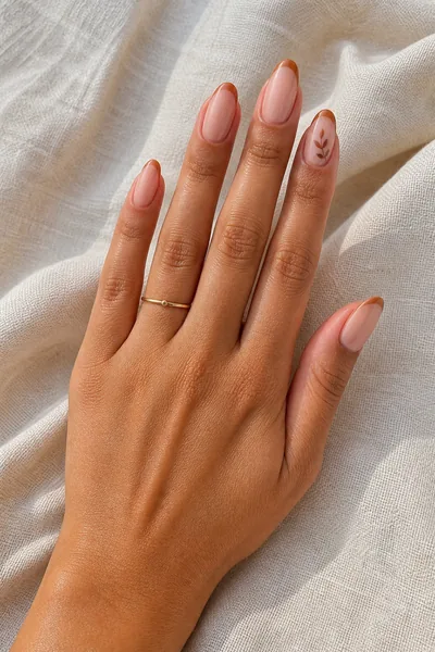 Caramel harvest French tips on medium almond nails with glossy finish, angled fingers in daylight, light skin tone