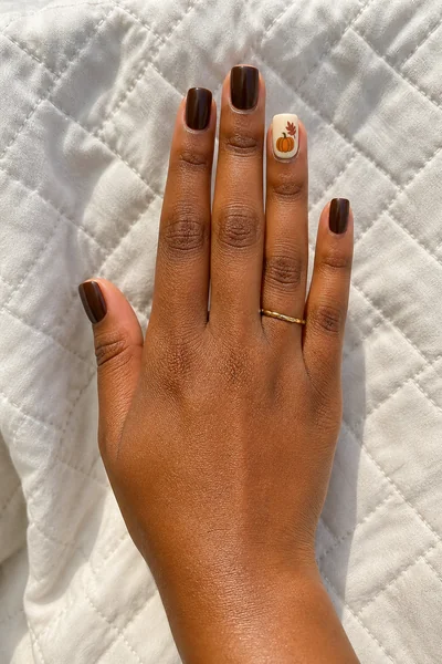 Chocolate and rust short harvest nail set on square shape with glossy finish, relaxed diagonal hand pose, warm deep skin tone