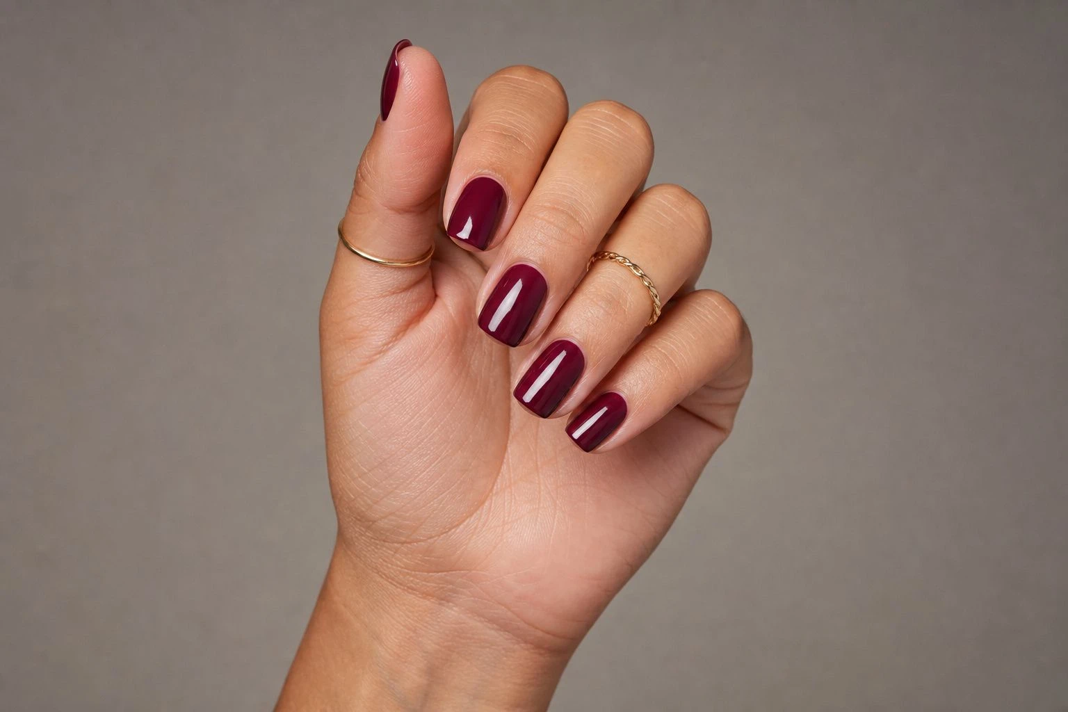 Short square berry wine manicure with two delicate gold rings, Christmas nail idea