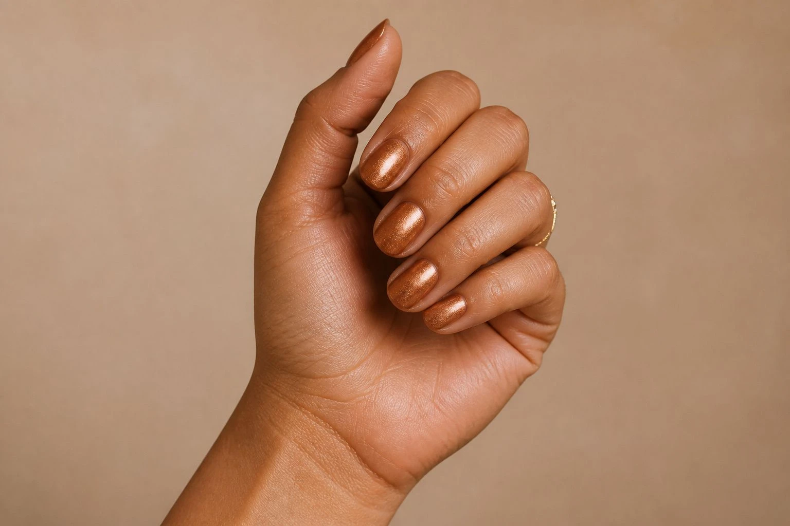 Short round copper shimmer manicure with a delicate gold ring, Christmas nail idea
